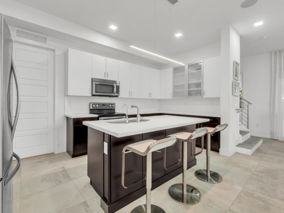 Cocina moderna con isla central y electrodomésticos en casa de Miami