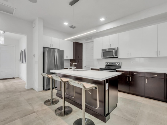 Cocina moderna con isla central y electrodomésticos en casa de Miami