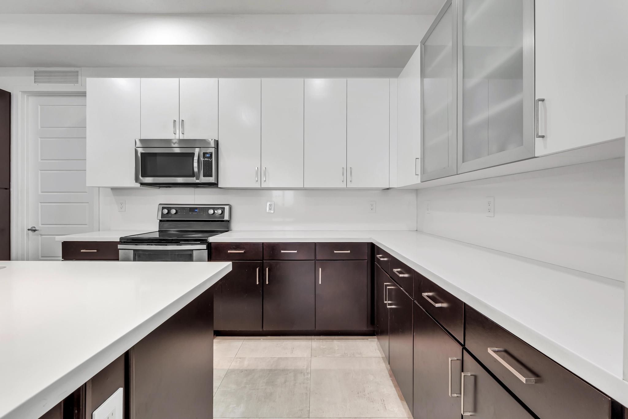 Modern kitchen with center island in Venetian Parc residence Cocina moderna con isla central y electrodomésticos en casa de Miami