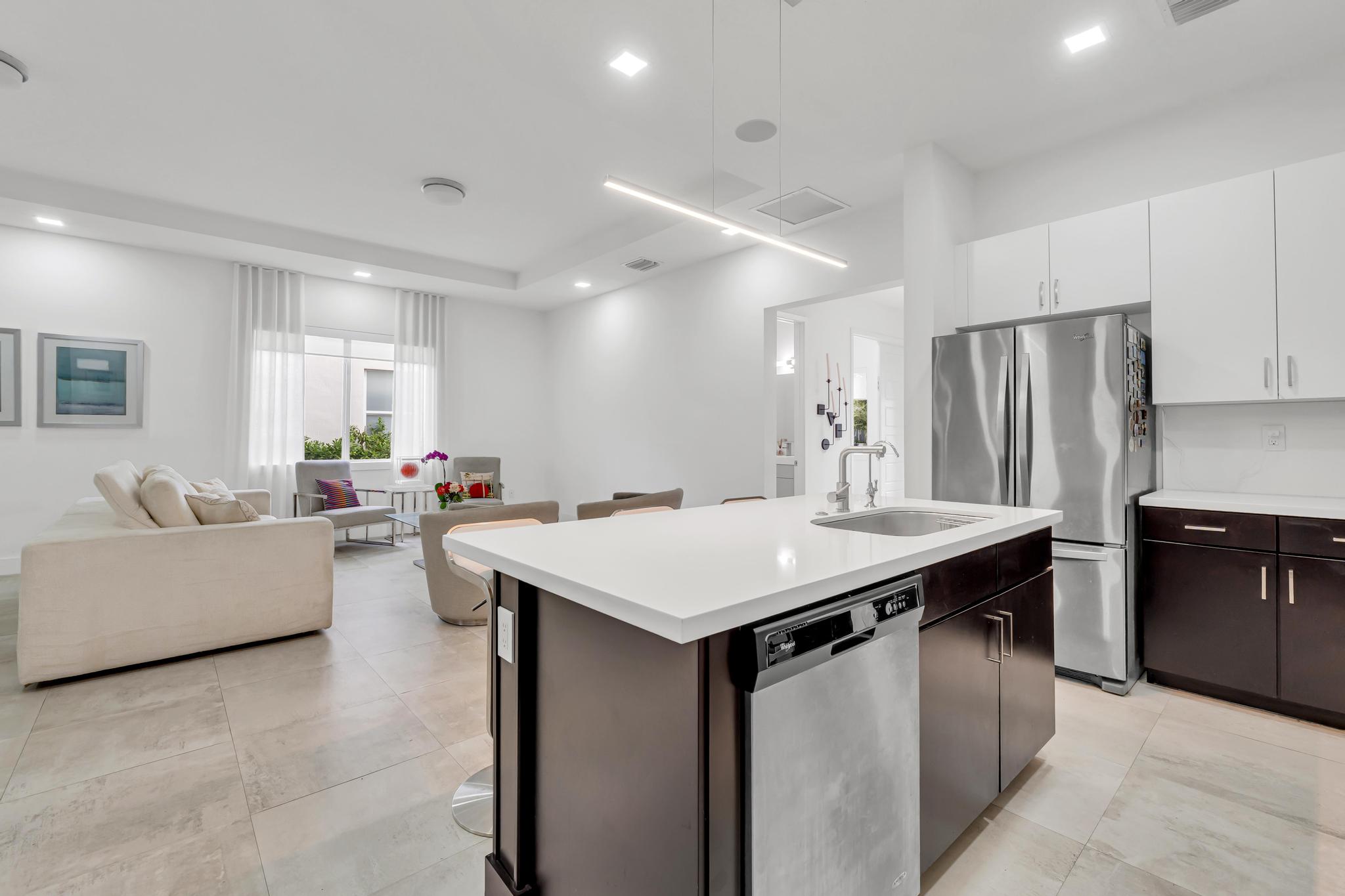 Modern kitchen with center island in Venetian Parc residence Cocina moderna con isla central y electrodomésticos en casa de Miami