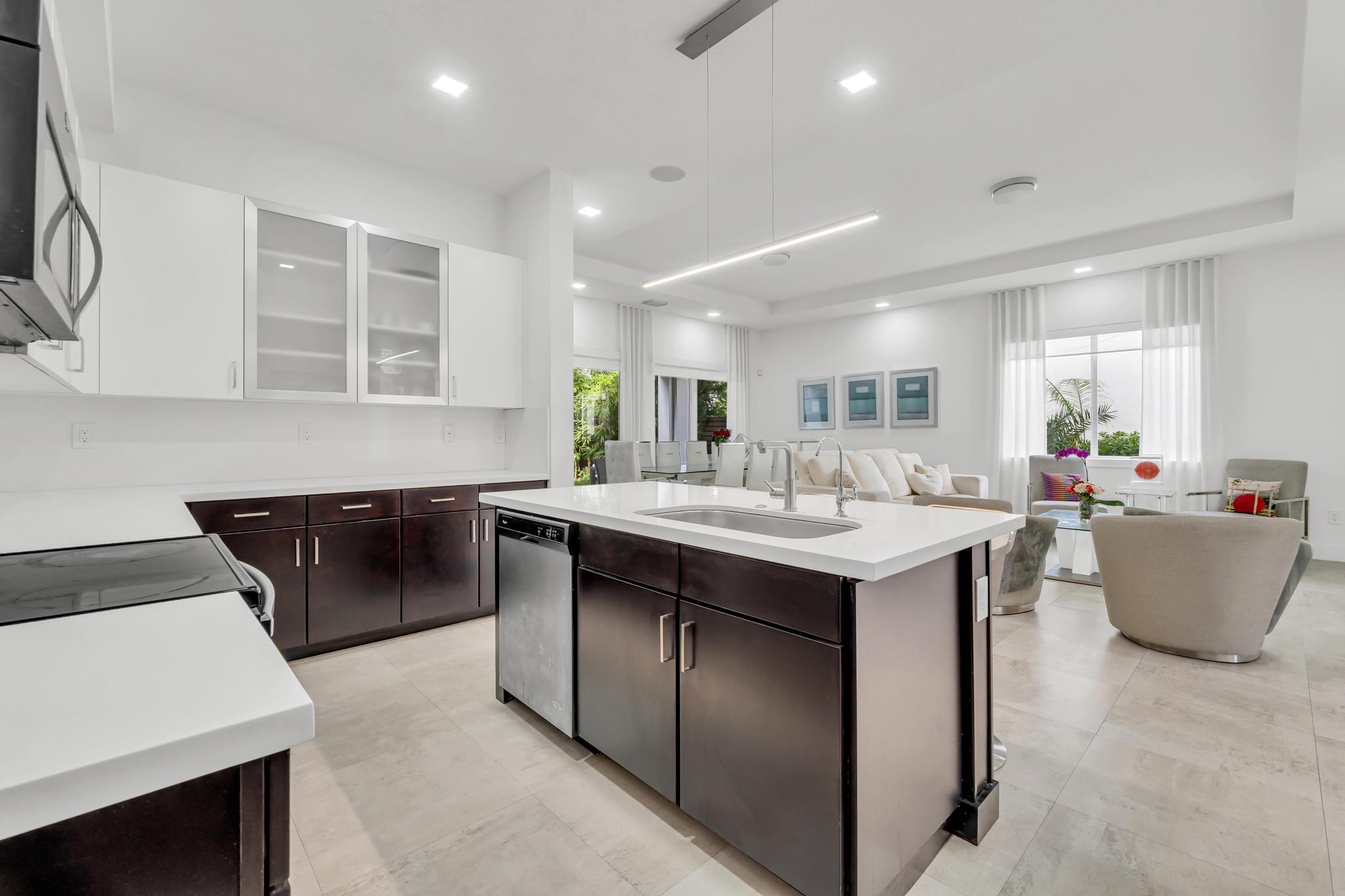 Modern kitchen with center island in Venetian Parc residence Cocina moderna con isla central y electrodomésticos en casa de Miami