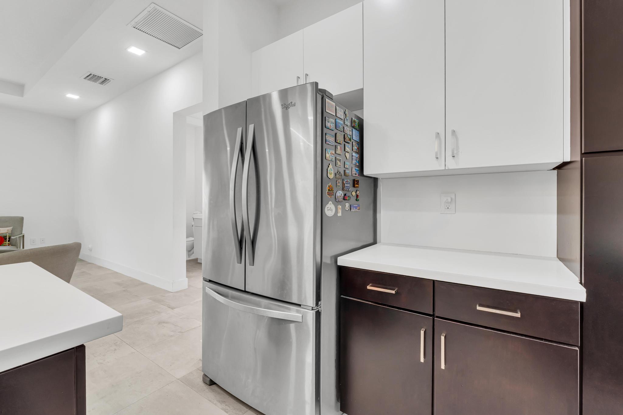 Modern kitchen with center island in Venetian Parc residence Cocina moderna con isla central y electrodomésticos en casa de Miami