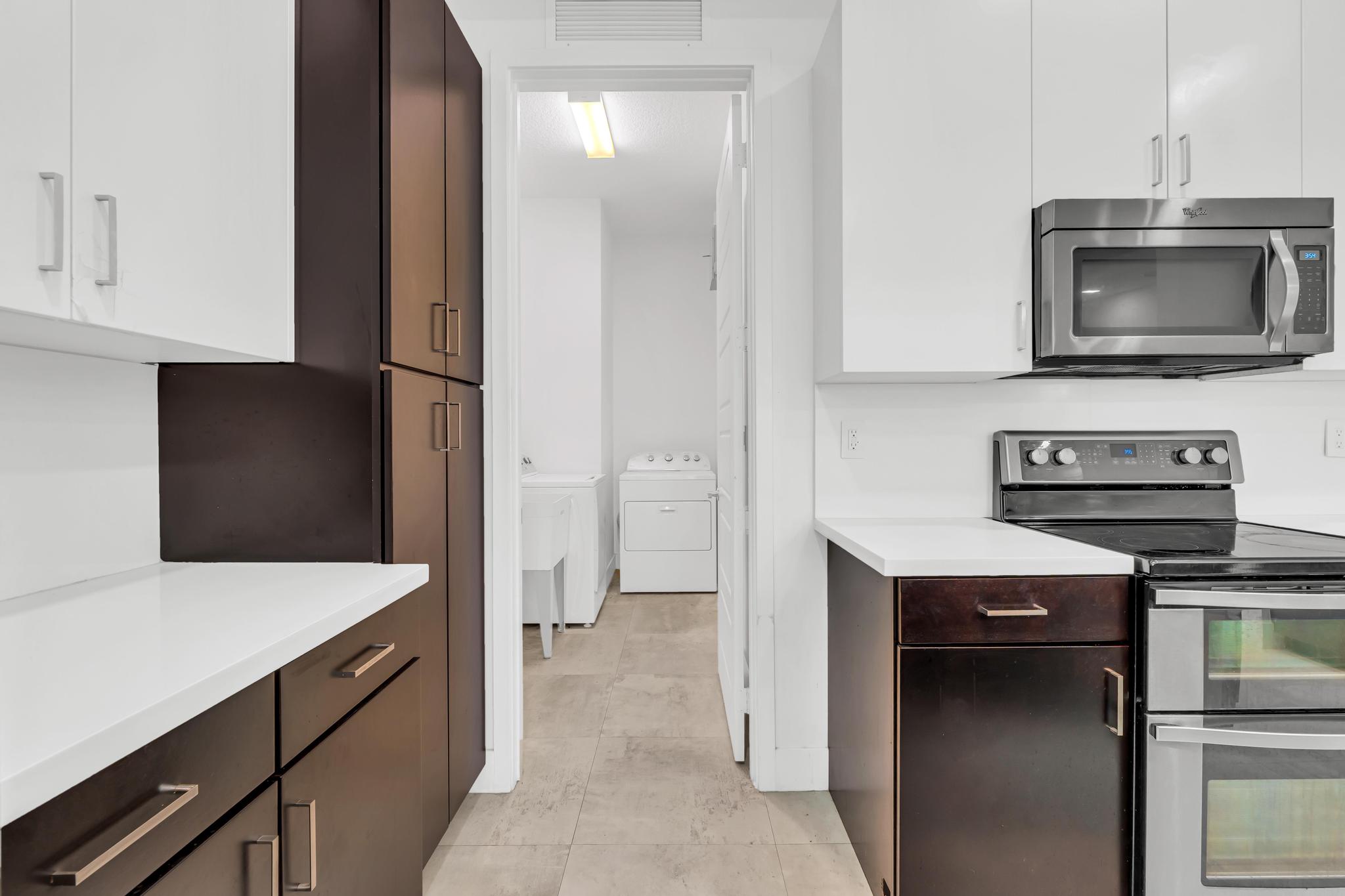 Modern kitchen with center island in Venetian Parc residence Cocina moderna con isla central y electrodomésticos en casa de Miami